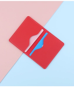 Detail view of slim red leather card holder with wavy slots and contrast stitching