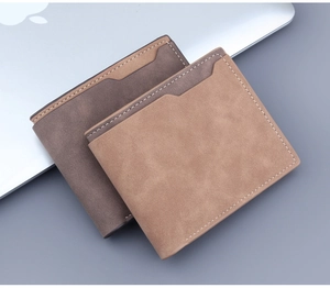 Detailed view of matte leather wallets with contrast stitching on a laptop background