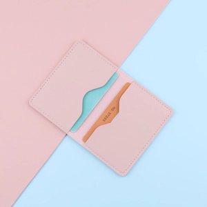Slim pink leather card holder with dual slots and elegant white stitching details