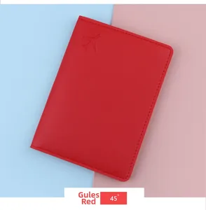 Detail view of a red leather passport cover with an embossed airplane logo on a blue background