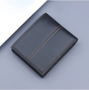 Detail of black leather wallet showing precise parallel orange contrast stitching and edges