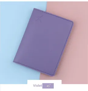 Close-up of violet passport holder with embossed airplane and neat stitching details