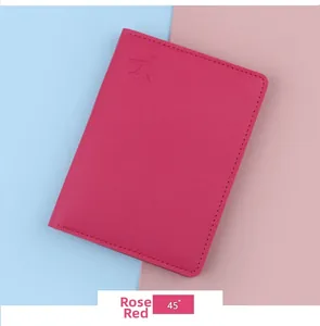 Close-up of rose red PU leather passport holder with airplane embossing and stitching