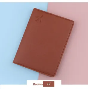 Close-up of brown faux leather passport cover with an embossed airplane and stitched edges