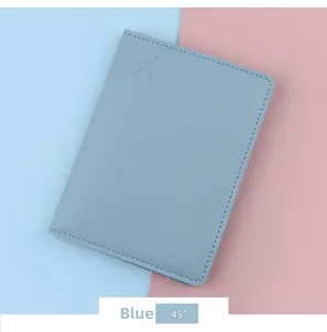 Detail of light blue PU leather passport holder with embossed airplane logo and stitching