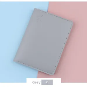 Close-up of a grey leather travel passport wallet featuring a debossed airplane icon detail