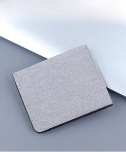 Detail of light gray canvas bifold wallet with premium fabric texture and black edge finish