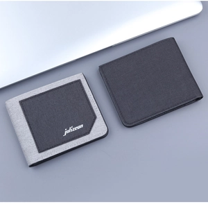 Detail of ultra-slim canvas wallets in grey and charcoal colors on a minimalist desk surface