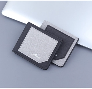 Macro shot of ultra-thin bifold canvas wallets in dual-tone grey on a business desk
