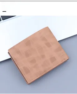 Detail of tan bifold men's wallet showing brushed texture and stitching on laptop background