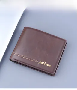 Short brown men's leather wallet with stitching detail and gold logo on gray background