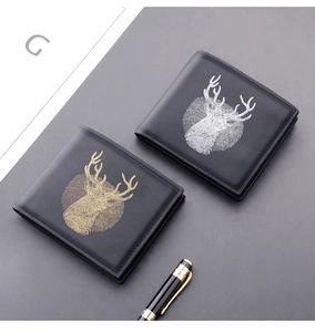 Close-up of black leather bifold wallets featuring gold and silver reindeer emblems