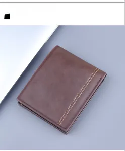 Detail of brown faux leather bifold wallet featuring double orange decorative stitching