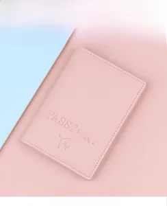 Detailed view of pink leather passport cover with airplane icon and fine grain texture