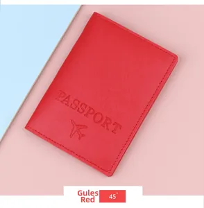 Detail of red leather passport holder with embossed logo and airplane icon on the cover