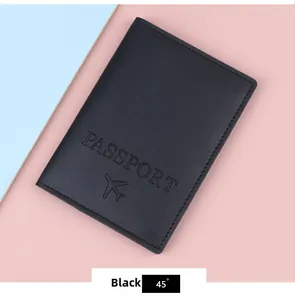 Detail of black leather passport cover with embossed text and airplane icon