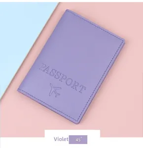 Detail of violet passport holder with embossed lettering and airplane icon on leather texture
