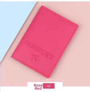 Close-up of rose red PU leather passport cover with embossed gold text and airplane icon