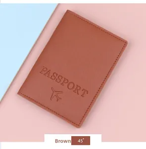 Brown leather passport cover featuring embossed lettering and aircraft icon at 45 degree angle