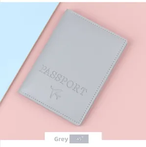 Detailed 45-degree angle of grey leather passport cover with embossed logo and text