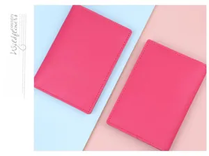 Detail of two rose pink passport covers with lychee texture and embossed plane icon