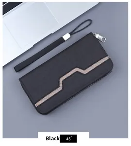 Close-up of black canvas clutch wallet with geometric pattern and wrist strap