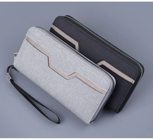 Detail view of canvas zip-around wallets with V-pattern texture and wrist straps
