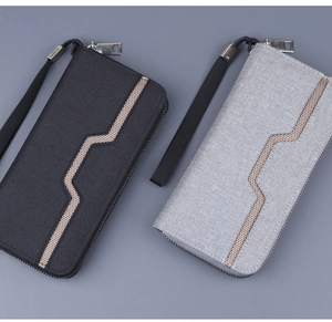 Detail view of canvas zip wallets in black and grey with geometric mesh pattern and wrist strap
