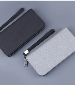 Detail view of canvas zip clutches in black and grey with woven texture and wrist straps