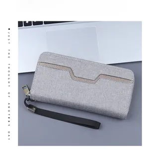 Detail of grey canvas men's wallet featuring mesh texture and metal zipper with wrist strap