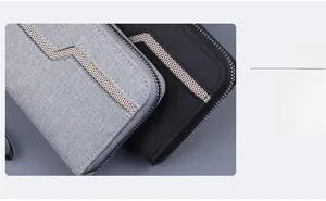 Detail of grey and black canvas long wallets with V-shaped mesh design and wrist strap