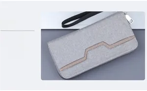 Detail of grey canvas wristlet bag showing breathable mesh trim and metal zipper