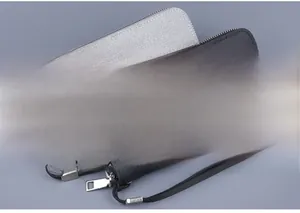 Detail of canvas long wallets in grey and black featuring zippers and wrist straps