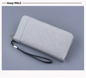 Detail of pale grey canvas wallet showing zip closure and black wristlet strap