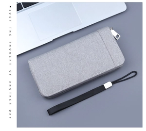 Detail view of grey canvas long wallet with silver zipper and detachable wrist strap
