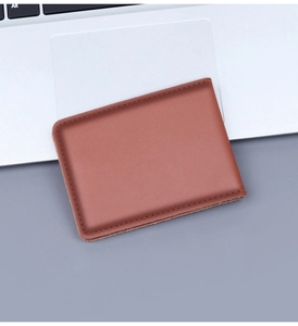 Étui de permis en cuir marron sur clavier d'ordinateur avec coutures de précision