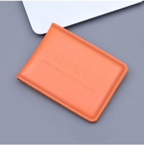 Detail view of orange genuine leather texture and embossed driving license lettering