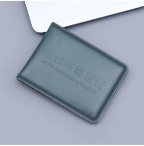 Detail of dark green top grain leather driving license cover with embossed lettering