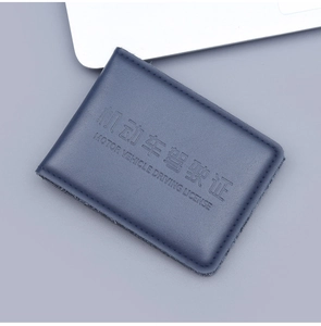 Macro view of blue leather driver license holder with precise stitching and embossed text