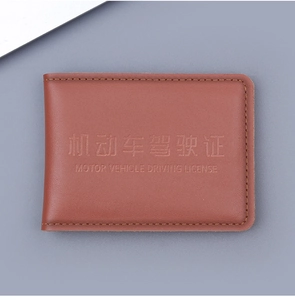 Detailed close-up of brown leather driving license holder with litchi texture and stitching