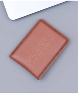 Detail of genuine brown leather driver license cover with fine stitching and embossed text