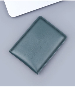 Close-up of dark green leather driving license cover with fine stitching and embossed text