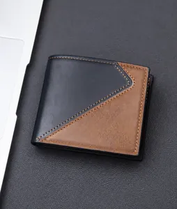 Short bi-fold men's wallet with black and brown leather texture near a laptop