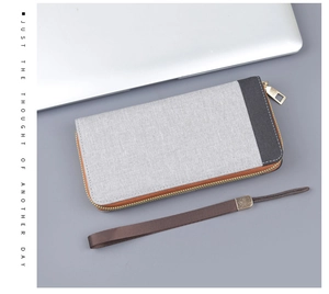 Detail of canvas clutch wallet showing contrast stitching and premium metal zipper