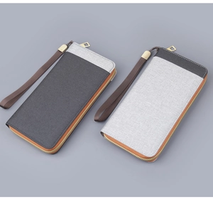 Detail of grey canvas men long wallets with golden zippers and wrist straps