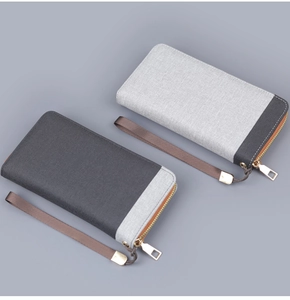 Close-up of canvas men's wrist bag featuring textured fabric and durable metal zipper