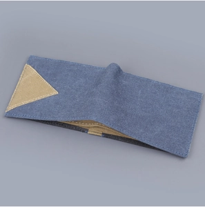 Detail of blue denim canvas wallet with a stylish khaki triangle patch and sturdy stitching