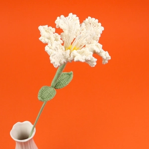 Handmade crochet crape myrtle flower with white petals and green leaves in a white ceramic vase
