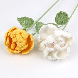 Detailed macro view of handmade crochet peony flowers in yellow and white yarn textures