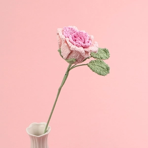 Detail showing the intricate hand-knitted texture of a pink crochet rose flower